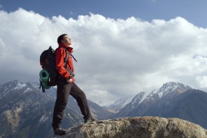 Climbing young adult at the top of summit